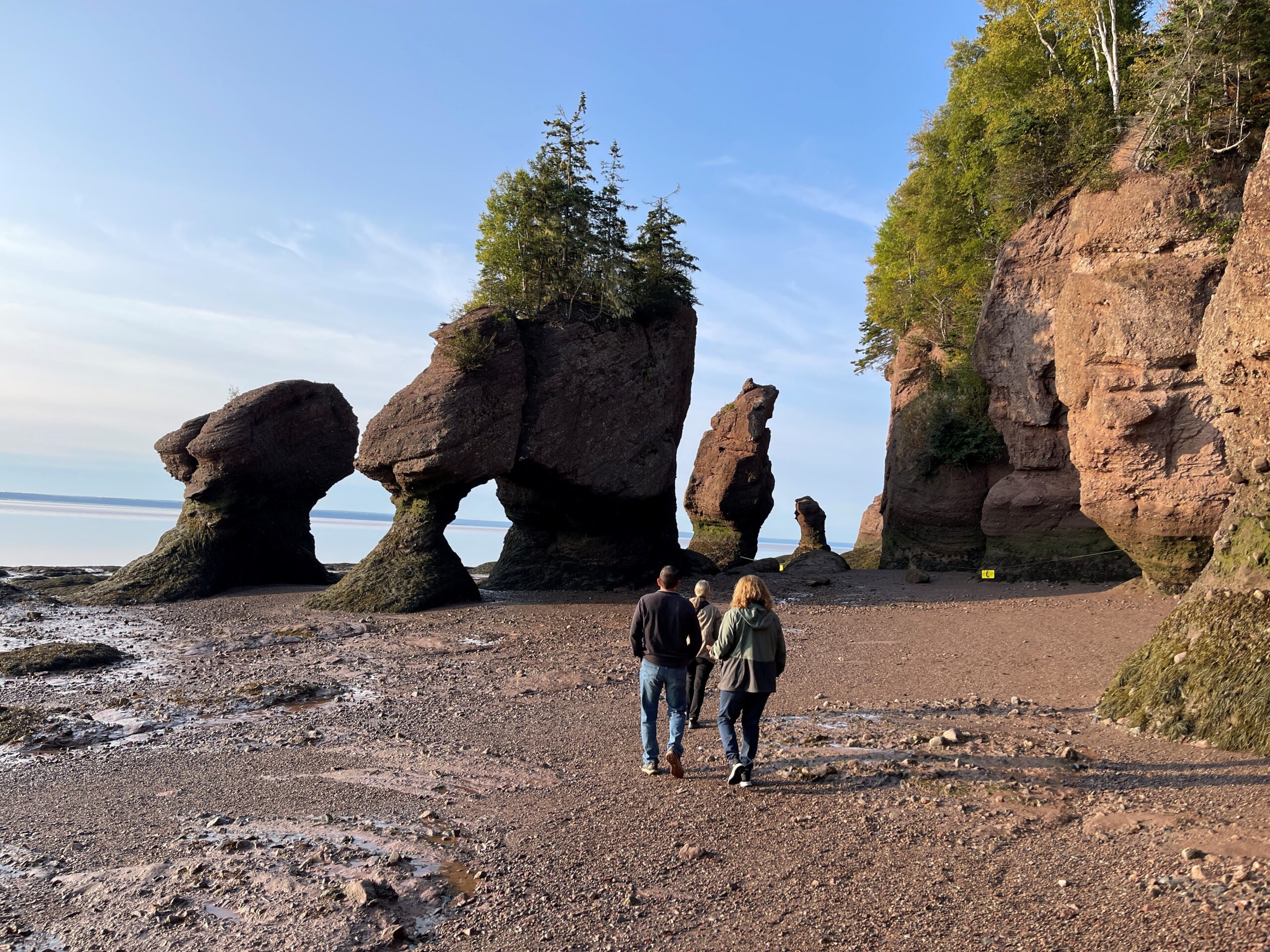 Bay of Fundy at low tide with three people walking on it